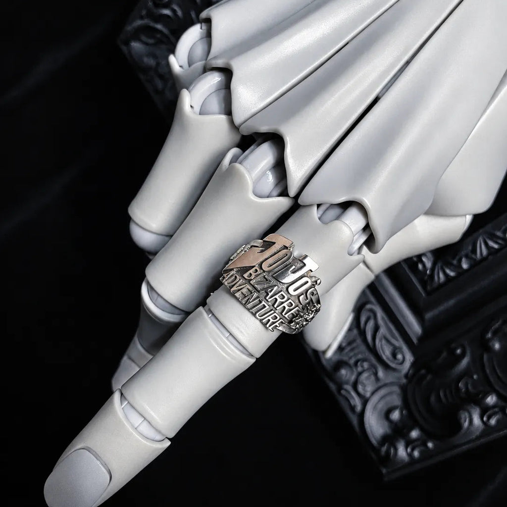 A close-up of a white articulated robotic hand wearing a silver ring engraved with '200 Jrs. Champion' and 'The Great White Hunter'.